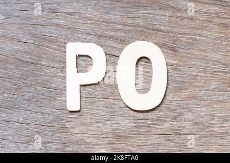 Buchstabenbuchstabe in Wort PO (Abkürzung der Bestellung) auf Holzhintergrund Stockfoto