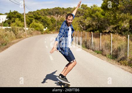 Mann genießt Skateboarding an sonnigen Tag Stockfoto