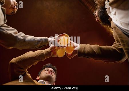 Unterseite der Freunde klirrende Bierkrüge Stockfoto