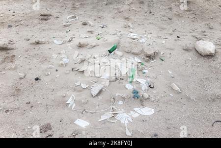 Müll auf einem Wüstensand weggeworfen. Stockfoto