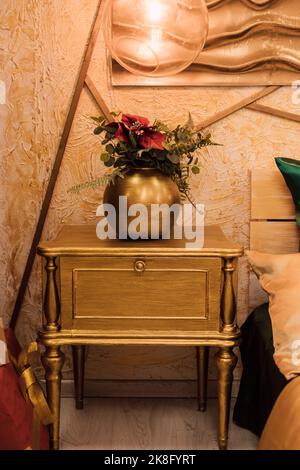 Nachttisch in Goldfarbe im Schlafzimmer. Inneneinrichtung Stockfoto