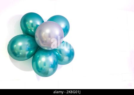 Blume aus Heliumballons in den Metallic-Farben grün und silber, auf weißem Hintergrund, Kopierraum rechts, horizontal Stockfoto