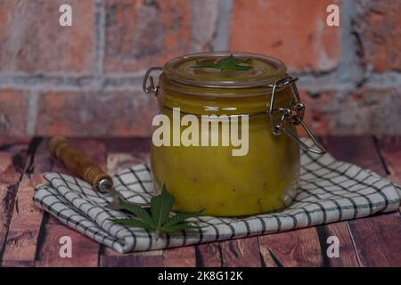 Yelllow Marihuana Butter auf dunklem Holztisch mit weißem Geschirrtuch Stockfoto