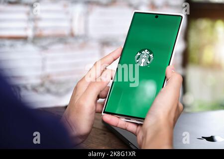 Chiang Mai, Thailand 06. Juni 2021:Frau Hand hält Smartphone Handy öffnen starbuck App Stockfoto