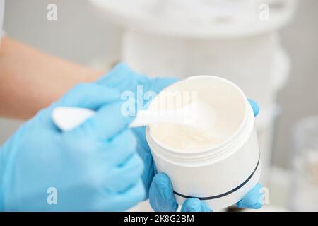 Glas Creme in den Händen der Kosmetikerin Stockfoto