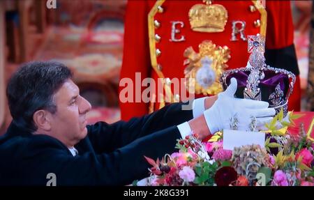 KRONJUWELEN Queen Elizabeth II. Bestattungsservice im Inneren der St. George's Chapel Windsor mit der Krone des kaiserlichen Staates, dem Wahrzeichen des britischen Sovereign, das der königliche Juwelier während der Trauerfeier auf dem Altar der königlichen Kapelle ausgestellt hat. Ein Beefeater Direktor des Turms steht hinter der Tür. 19/09/2022 Saint Georges Chapel Windsor Berkshire UK Stockfoto