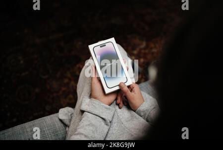 London, Vereinigtes Königreich - 28. Sep 2022: POV Frau Hand hält das Paket des neuen Apple Computers iPhone 14 Pro Smartphone Stockfoto