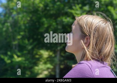 Blonde Teenager Mädchen erkundet Ziele bei Sonnenlicht Stockfoto