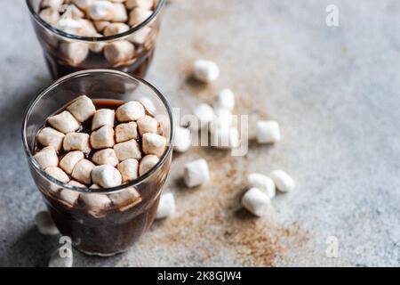 Heiße Schokolade mit Mini-Marschmalow im Glas auf Betongrund Stockfoto