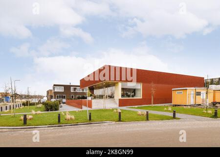Außenansicht eines modernen Gebäudes mit verspiegelten Glasfenstern vor blauem Himmel und Wolken Stockfoto