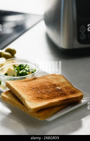 Zwei Toast mit in Scheiben geschnittener Avocado, Butter und Käse für ein gesundes Sandwich. Nahaufnahme. Stockfoto