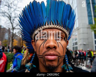 Ein indigener Mann sah während des klimamarsches blaue Federn tragen. Tausende von Menschen versammelten sich während eines von der Climate Coalition (einer nationalen Non-Profit-Organisation, die mehr als 90 Organisationen zum Thema Klimagerechtigkeit zusammenbringt) organisierten klimamarsches vor dem Brüsseler Nordbahnhof, um gegen das Fehlen von Maßnahmen gegen die Klimakrise zu protestieren. Mit diesem märz fordern sie, die Energiekrise mit einer einheitlichen Energiepolitik zwischen den Regionen und dem Bundesland zu bekämpfen, die es Belgien ermöglicht, bis 2050 100 % erneuerbare Energien zu erreichen, und die Agrarkrise zu bekämpfen Stockfoto