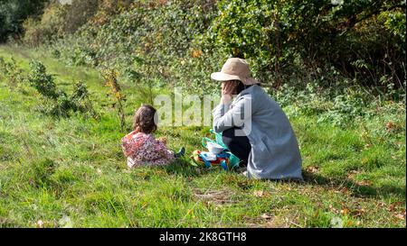Eine Mutter und Tochter genießen ein Picknick auf einem Feld. Stockfoto