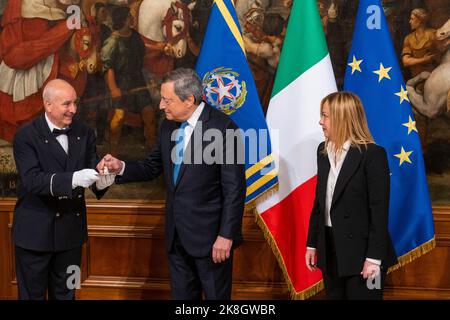 Rom, Italien. 23. Oktober 2022. Italiens neu ernannte Premierministerin Giorgia Meloni erhält während der „Glockenzeremonie“ im Palazzo Chigi in Rom eine kleine silberne Glocke vom ehemaligen Premierminister Mario Draghi. Die „Glockenzeremonie“ stellt die Übergabe zwischen dem scheidenden Premierminister und dem, der die neue Regierung führen wird, dar. Giorgia Meloni ist auch die erste Frau, die in Italien als Premierministerin dient. Kredit: SOPA Images Limited/Alamy Live Nachrichten Stockfoto