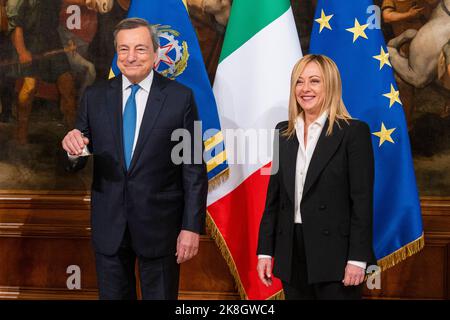 Rom, Italien. 23. Oktober 2022. Italiens neu ernannte Premierministerin Giorgia Meloni erhält während der „Glockenzeremonie“ im Palazzo Chigi in Rom eine kleine silberne Glocke vom ehemaligen Premierminister Mario Draghi. Die „Glockenzeremonie“ stellt die Übergabe zwischen dem scheidenden Premierminister und dem, der die neue Regierung führen wird, dar. Giorgia Meloni ist auch die erste Frau, die in Italien als Premierministerin dient. Kredit: SOPA Images Limited/Alamy Live Nachrichten Stockfoto