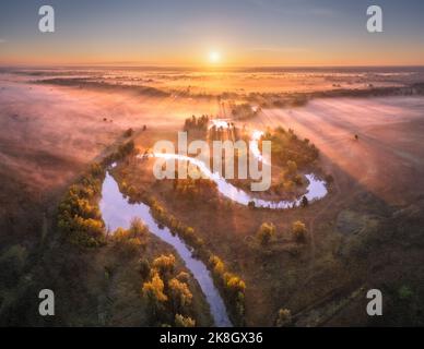 Luftaufnahme des wunderschönen geschwungenen Flusses in niedrigen Wolken bei Sonnenaufgang Stockfoto