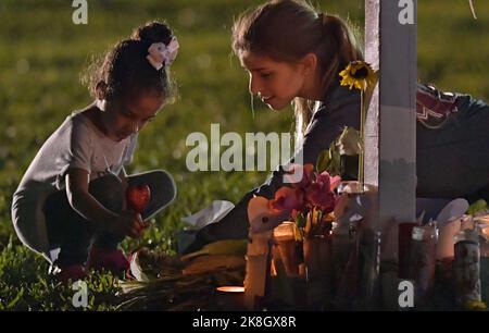 PARKLAND, FL - 16. Februar: Eine junge Frauen Orte Blumen an einer Gedenkstätte, ehrt die Opfer der Masse schießen auf Marjory Stoneman Douglas High School, At Pine Trail Park am 16. Februar in Parkland, Florida 2018. Polizei verhaftet 19-jährigen ehemaligen Schüler Nikolas Cruz für die Ermordung von 17 Personen an der High School. Personen: Atmosphäre Stockfoto