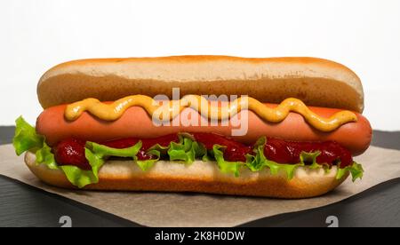 Frisch gekochter Hot Dog liegt vor dem Servieren auf Pergamentpapier Stockfoto