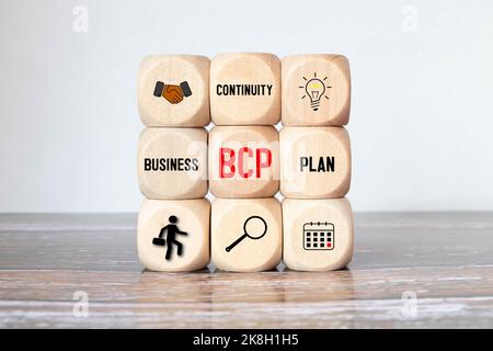 BUSINESS-CONTINUITY-PLAN, Text auf Holzblock auf grauem HINTERGRUND Stockfoto