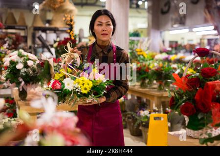 Weibliche Floristin, die im Blumengeschäft arbeitet Stockfoto