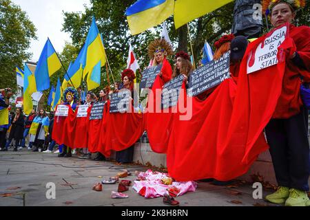 London, Großbritannien. 23. Oktober 2022. Eine Gruppe von Demonstranten sah, wie sie während der Demonstration Blumenhedressen trugen und Plakate trugen. Dutzende von Demonstranten nahmen an einer Kundgebung Teil, um Solidarität mit der Ukraine zu zeigen und forderten Sanktionen gegen Russland. Der Krieg zwischen Russland und der Ukraine ist seit Februar 2022 in 8. Monaten eingetreten. Kredit: SOPA Images Limited/Alamy Live Nachrichten Stockfoto