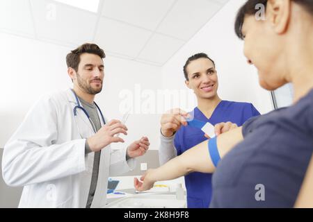 Krankenschwester, die einen Wirbelkörper auf dem Patienten für einen Bluttest vorbereitet Stockfoto