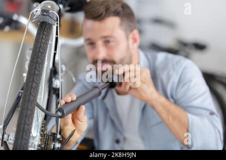 Mann pumpt ein Rad hoch Stockfoto
