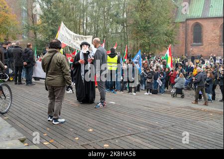 Demonstration gegen die iranische Regierung. Zeigt einen Mann mit Blut an den Händen, der eine Maske trägt, die dem iranischen Präsidenten ähnelt Stockfoto