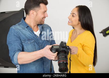 Fotograf und Model bei der Überprüfung der Fotokamera Stockfoto