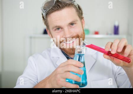 Bild eines jungen Chemikers, der mit Substanzen experimentiert Stockfoto