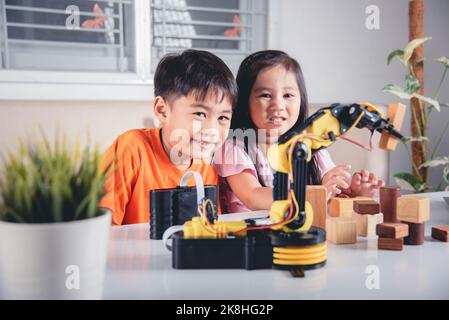 Zwei Kinder programmieren und testen Roboter ARM ihre Wissenschaft, Kid kleines Mädchen Programm Code zu Roboter mit Laptop-Computer und der Junge testen mit Fernbedienung Stockfoto