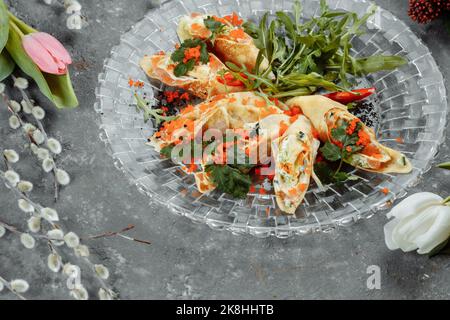 Dünne Pfannkuchen mit Kaviar und Lachs, zu Rollen gerollt Stockfoto