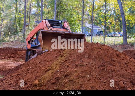 Auf Baustellen werden kleine Traktoren zum Transport von Boden für die Landschaftsgestaltung verwendet Stockfoto