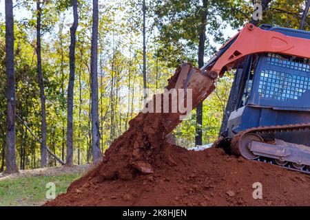 Kleiner Traktor, der auf der Baustelle verwendet wird, um den Boden für Landschaftsbauzwecke zu bewegen. Stockfoto