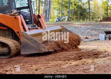 Der kleine Traktor wird für die Bodenbewegung auf der Baustelle durch Bodenbewegung verwendet Stockfoto