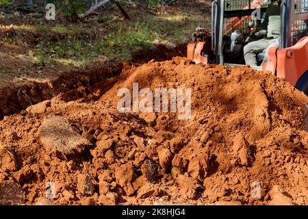 Kleiner Traktor verwendet, um Boden in Baustellen landschaftlich gestalteten Bereich aus Landschaftsbau Aufgaben zu bewegen. Stockfoto