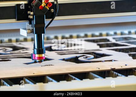 Laserschneidemaschine, Schneiden von Holzplatten, während ein Mann kümmert sich um den Prozess, lateinamerika Stockfoto