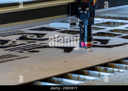 Laserschneidemaschine, Schneiden von Holzplatten, während ein Mann zeichnet den Prozess, mexiko Stockfoto