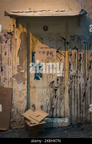 Metalltür zu einem Gebäude mit lackierten Wänden in Sheung Wan, Hong Kong Island Stockfoto