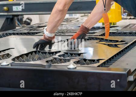 Laserschneidemaschine, Schneiden von Holzplatten, während ein Mann kümmert sich um den Prozess, lateinamerika Stockfoto