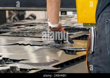 Laserschneidemaschine, Schneiden von Holzplatten, während ein Mann kümmert sich um den Prozess, lateinamerika Stockfoto