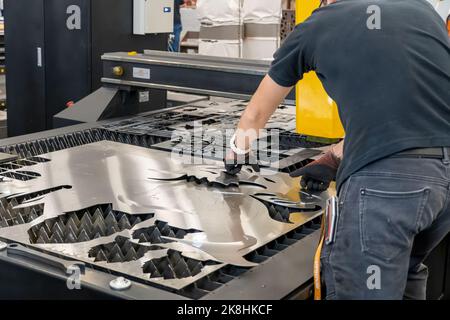 Laserschneidemaschine, Schneiden von Holzplatten, während ein Mann kümmert sich um den Prozess, lateinamerika Stockfoto