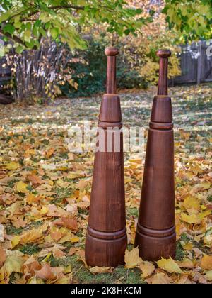 Ein paar traditionelle persische Holzmaalen in einem Hinterhof in Herbstlandschaft. Sie entstanden in Persien (heute Iran), als eine wichtige Kraftaufbauübung. Stockfoto