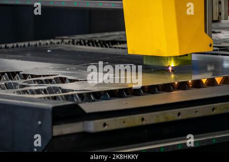 Laserschneidemaschine, Schneiden von Holzplatten, während ein Mann zeichnet den Prozess, mexiko Stockfoto