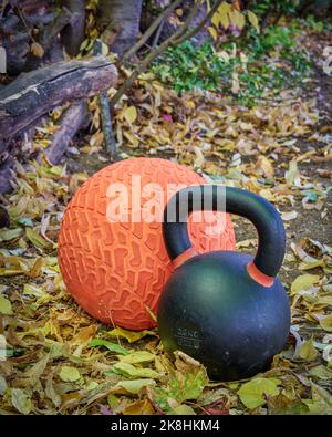 Schwere eiserne Kugelhantel und Slam Ball in einem Hinterhof, Herbstlandschaft Stockfoto