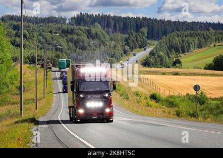 Scania R650 LKW-Sattelauflieger voWa Transporte, Schweiz mit hellen Scheinwerfern im Konvoi zur Power Truck Show. Pirkanmaa, Finnland. August 11, 2022. Stockfoto