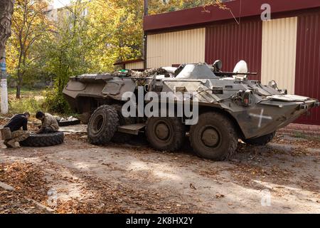 Bakhmut, Ukraine. 19. Oktober 2022. Ukrainische Soldaten wechseln die Reifen auf einem APC, einem gepanzerten persönlichen Träger der ukrainischen Armee in der Nähe eines beschädigten Gebäudes nach einem russischen Beschuss in der Stadt Bakhmut. Bakhmut ist eine der am schlimmsten beschossen Städte an den Fronten des Donbass-Krieges, seit Russland am 24. Februar 2022 seine umfassende Invasion in der Ukraine startete. (Foto von Jan Husar/SOPA Images/Sipa USA) Quelle: SIPA USA/Alamy Live News Stockfoto