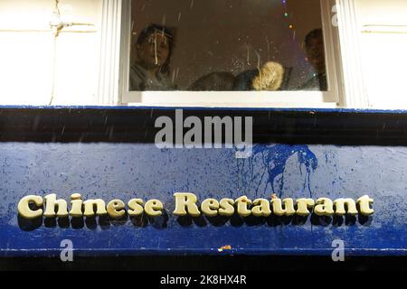 London, Großbritannien. 23. Oktober 2022. Ein frisches zerbrochenes Ei, das an der Außenseite eines chinesischen Restaurants gesehen wird, während die Menschen im chinesischen Restaurant aufblicken, als die Demonstranten am 23. Oktober 2022 in China Town in London, Großbritannien, eintreffen.Hunderte von Menschen versammeln sich in der Downing Street'‹, Dann'''‹ marschieren unter einem plötzlichen Regensturm in London über Chinatown zur chinesischen Botschaft, um gegen den Überfallereignis zu protestieren, bei dem ein Hongkonger Protestler Bob Chan, der am 17. Oktober 2022 auf dem Gelände eines chinesischen Konsulats in Manchester von Mitarbeitern geschlagen und geschlagen wurde, gesehen wurde. (Bild: © May James/ZUMA Bild: ZUMA P Stockfoto