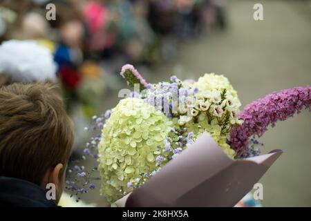 Festlicher Blumenstrauß. Blumen im Kind. Der Unterricht bringt dem Lehrer Blumen. Details zum Urlaub. Stockfoto