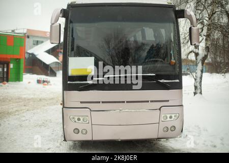 Bus auf dem Parkplatz. Transport im Winter. Öffentliche Verkehrsmittel in der Stadt. Windschutzscheibe des Fahrzeugs. Stockfoto